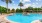 Large u-shaped pool with abundant seating and lush tropical foliage